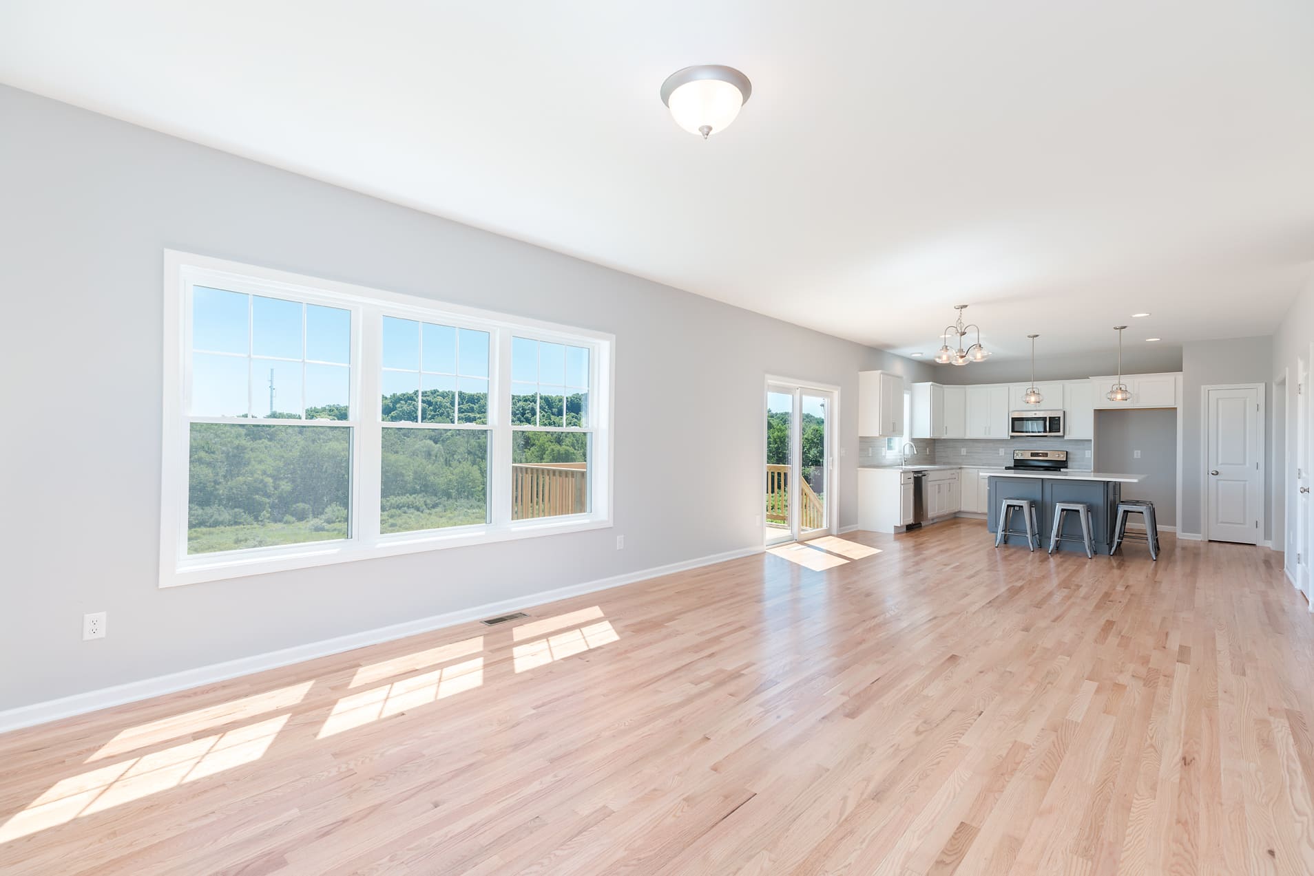 Beautiful Open Living Space with Large Window and View of Kitchen  | Sunwood Home Builders & Remodelers